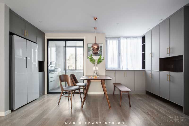 因為廚房格局較小，所以體積龐大的雙開門冰箱被安置在外部的定制柜內(nèi)，平日里在客廳休息時取用放置也很方便。