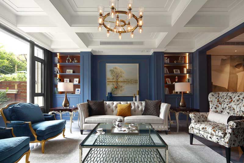 客廳的立面有兩處裝飾柜，兩面相對稱呼應(yīng)。裝飾上運用涂料和護墻的手法，使空間豐富感更強。深灰色地磚一鋪到底，從客廳一直延伸到餐廳，并鋪上米灰色地毯做裝飾，使空間色彩更加柔和。