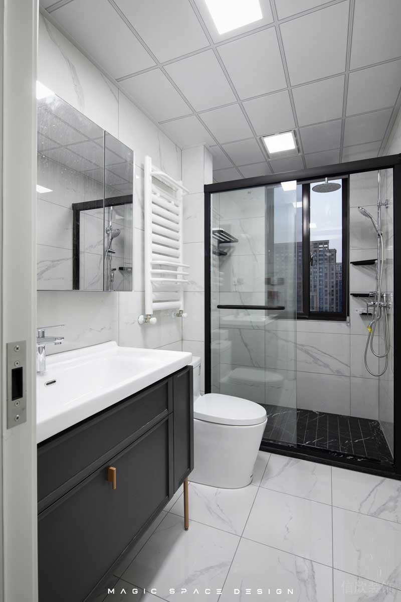 白色的大理石磚面讓采光受限的主衛(wèi)空間緩解了尷尬，布局中實用與時尚并舉，基礎(chǔ)的干濕分離，黑色邊框的淋浴拉門，搭配上深黑的防滑地磚，除了滿滿的肌理感也有區(qū)分的作用。