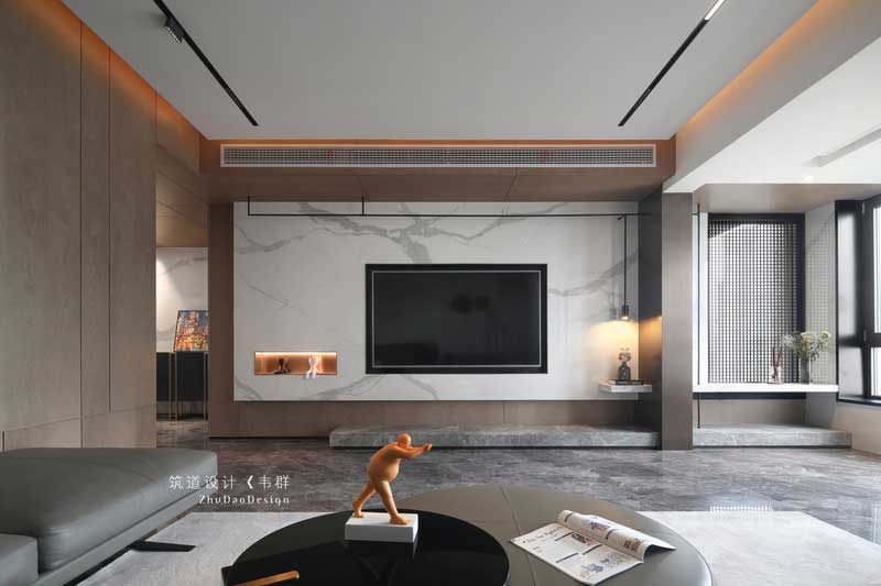 設(shè)計師巧妙地運用色彩和燈光，把看似獨立的空間完全打開并融于整體。木色的護墻、簡潔的裝飾、大理石電視背景以及擺放家具中夾雜的跳色的點綴，將原本素雅大氣的空間變得有了些許生活氣息。